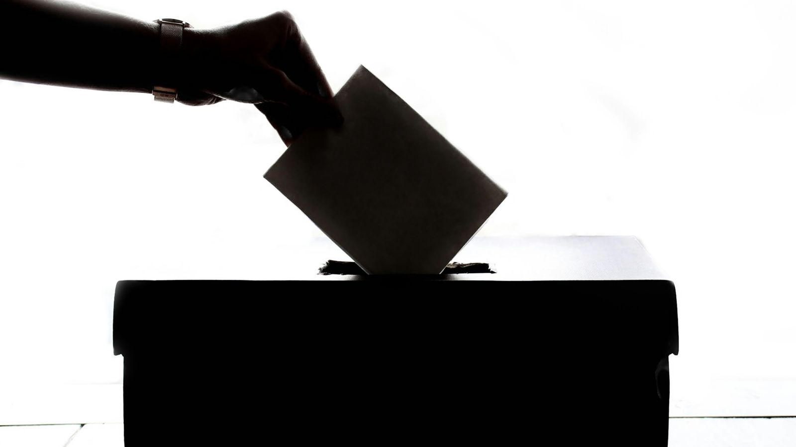 una persona esta emitiendo un voto en una casilla