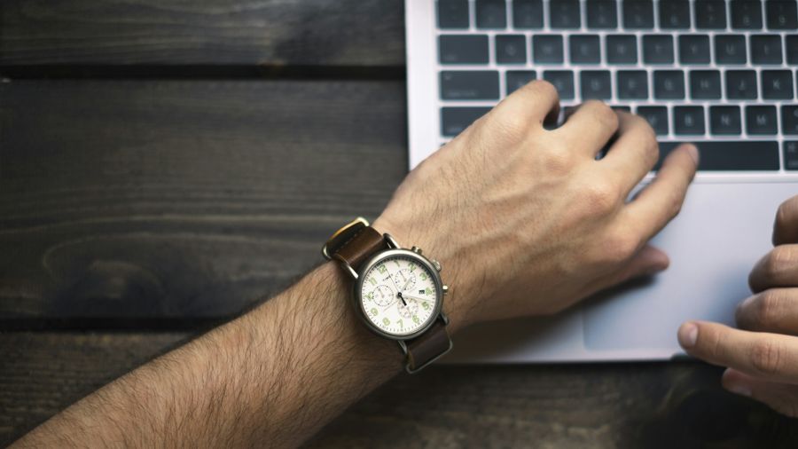 persona que lleva reloj marron y blanco